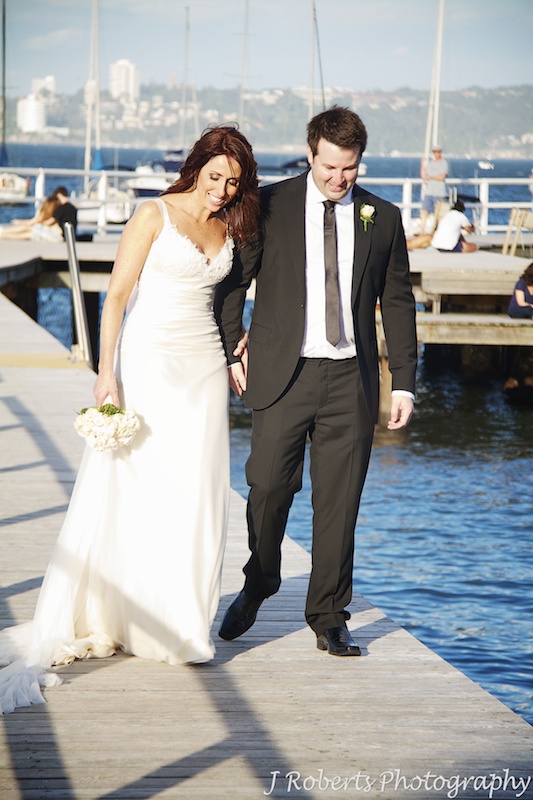Bride and groom walking hand in hand in afternoon sunlight - wedding photography sydney